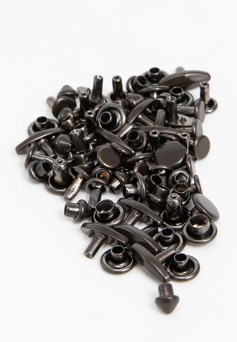 Kolekcja czarnych metalowych zapięć, zawierająca różne kształty, takie jak zaokrąglone, płaskie i cylindryczne, z niektórymi z nich o błyszczącym wykończeniu.