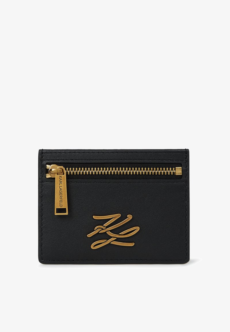Melnas ādas kartes turētājs ar zelta rāvējslēdzēju un vilkšanas cilpiņu, priekšpusē ar zelta "KL" inicialēm.