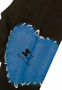 Maglietta nera con grafica circolare a gradiente blu. Presenta testo stilizzato e un logo a stella etichettato "BLACK LABEL". La texture del tessuto è liscia.