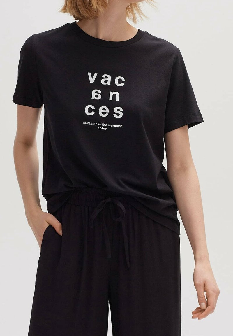 Svart bomullströja med vit text "vacances" och "summer is the warmest color", med en avslappnad passform och rundad halsringning.