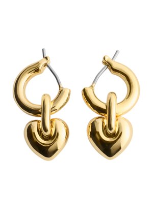 Boucles d'oreilles créoles en or ornées de breloques en forme de cœur poli suspendues, maintenues par des tiges en argent visibles.