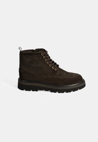 Bruine suède enkelboot met een ronde neus, een textuur oppervlak, metalen oogjes en een robuuste zwarte rubberen zool. Bevat een trekhaak aan de achterkant.