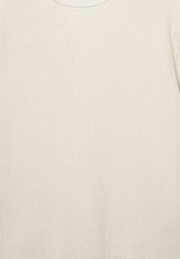 Texture de tissu tricoté couleur crème avec de fines côtes, montrant un gros plan du tissage et du motif textile.