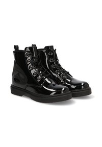 Botines de charol negros con punta redonda, suela gruesa y ojales plateados. Presentan un diseño de cordones y un tirador en la parte posterior.
