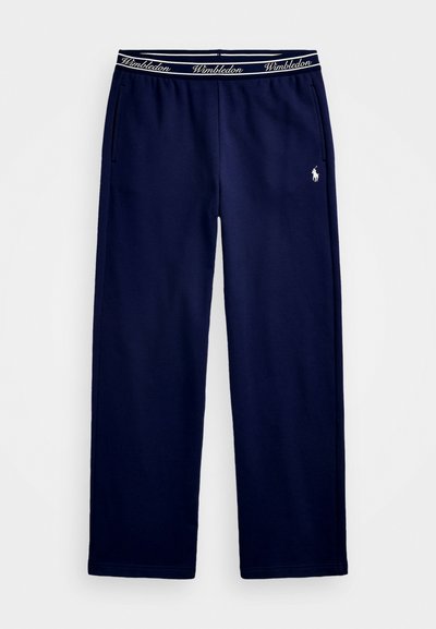 Marinefarvede sweatpants med elastisk talje, der har "Wimbledon"-tekst. Indeholder sidelommer og et lille logo på venstre lår.