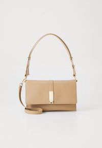 Beżowa torba na ramię z ekoskóry z klapą, złotymi okuciami, odpinanym paskiem na ramię i dwoma górnymi uchwytami. Gładka faktura, minimalistyczny design.