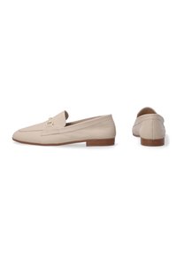 Beige læder loafers med flad hæl, lukket tå og dekorativ hardware detalje foran, med en glat finish og minimal syning.