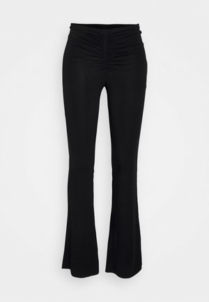 Pantalon noir taille haute évasé avec un détail froncé au centre de la ceinture devant, présenté sur un fond uni.