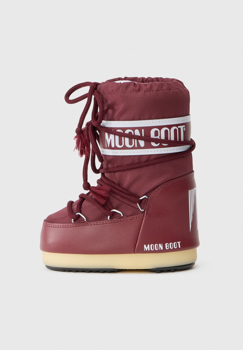 Burgundowe buty zimowe Moon Boot z grubą podeszwą, wyściełanym cholewką, białym paskiem z logo i owiniętymi sznurówkami na jednolitym jasnym tle.