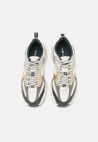 Lacoste sportcipők légáteresztő hálós felső résszel, fehér, szürke és olíva zöld részletekkel, párnázott talppal és fűzős kivitelben.