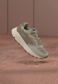 Jasno beżowe sneakersy wykonane z siateczki i zamszu, z teksturowaną powierzchnią, okrągłym noskiem, sznurowadłami i rowkowaną podeszwą. Gruba konstrukcja z bocznymi akcentami.