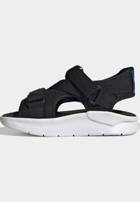 Black adjustable strap sport sandal with breathable mesh upper and thick white cushioned sole, side view on light background.