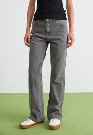 Gray denim jeans with a straight leg design, five pockets, and belt loops, paired with white sneakers and a black fitted top.