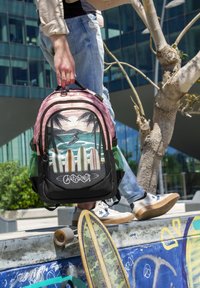 Mochila con un diseño en rosa y negro que presenta palmeras, tablas de surf y olas del océano, con bolsillos de malla verde y cierres de cremallera.