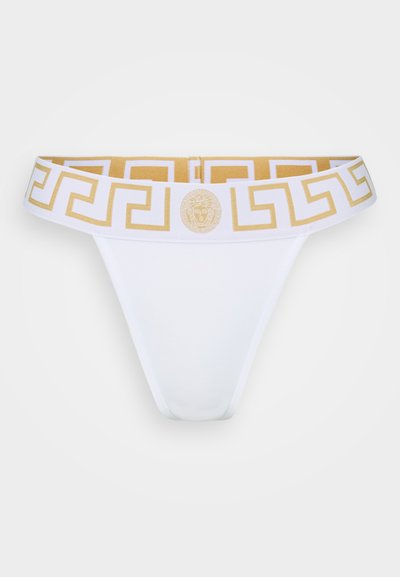 Balts thong ar zelta grieķu atslēgas raksta jostas vietu, kurai ir medaljons logo. Gluda auduma salikums ar pieguļošu dizainu.
