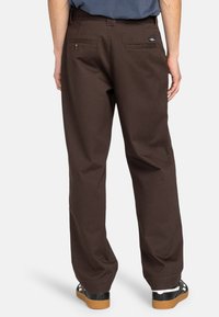 Brown wide-leg trousers with a smooth texture, featuring two back pockets and a small logo patch on the right pocket.