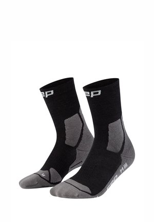 Paar schwarze und graue Sportsocken bis zur Mitte der Wade mit gepolsterten Bereichen und weißem Markenschriftzug nahe Bündchen und Sohle.