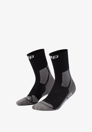 Paar schwarze und graue Sportsocken bis zur Mitte der Wade mit gepolsterten Bereichen und weißem Markenschriftzug nahe Bündchen und Sohle.