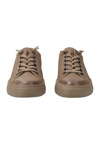 Bruna lädersneakers med rund tå, beige gummisula och textilskosnören. Har svarta öglor och sydda detaljer.