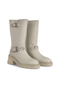 Botas de piel beiges hasta la rodilla con cremallera lateral, suela gruesa y hebilla decorativa con strass en una correa ajustable.