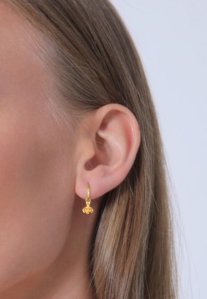 Goldene Creolen mit einem kleinen Bienenanhänger, der filigrane Details auf den Flügeln und am Körper aufweist, und der an einer dünnen, glatten Creole hängt.