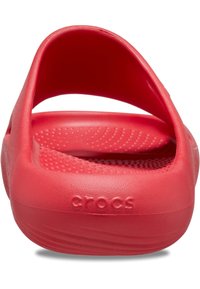 Zuecos rojos de Crocs con un exterior de plástico liso, que cuentan con una correa en la parte posterior y una plantilla texturizada con puntos elevados para agarre. Logotipo grabado en el lateral.
