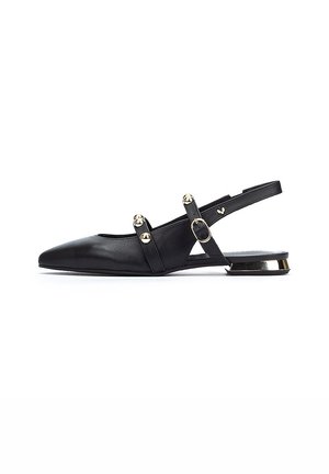 Mocasines de cuero negro con punta afilada, que cuentan con dos tachuelas decorativas doradas y una delgada correa en el tobillo. Tacón bajo con acentos dorados.