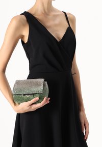 Metallinen clutch, jossa on kristallikoristeluja ja vihreä ombre-gradientti. Suorakulmainen muoto, ylhäältä suljettavalla kiinnityksellä ja teksturoidulla pinnalla.