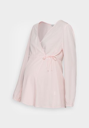 Blusa de maternidade rosa claro com mangas longas, faixa na cintura e uma textura suave e fluida. Apresenta um decote em V.