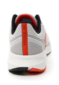 Baskets de sport en mesh gris avec des accents orange et noir, un col rembourré et une semelle en caoutchouc blanc présentant des détails texturés et un branding.