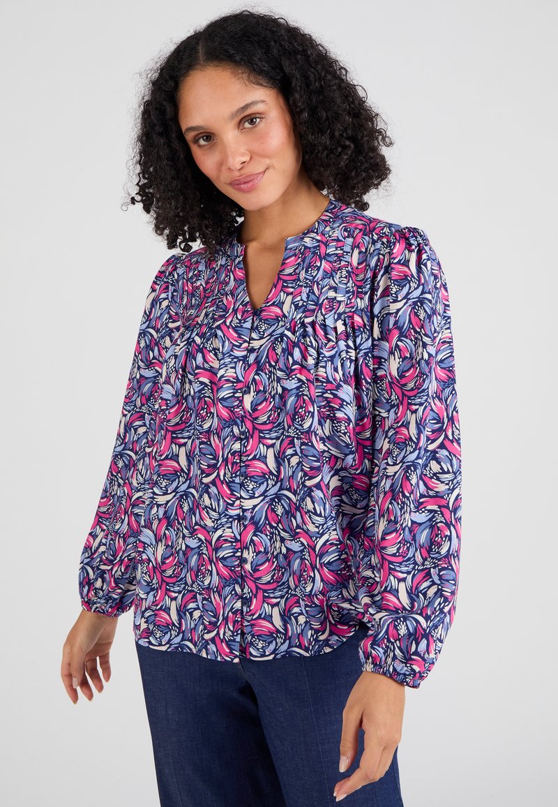 Langsleevige blouse met bloemenprint in roze, blauw en crème kleuren. Bevat een V-hals en gatherdetails op de schouders. Lichtgewicht stof.