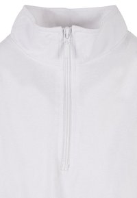 Hvit zip-up genser med stående krage, laget av strukturert stoff med en skjult glidelås. Enkelt design uten ekstra mønstre eller detaljer.