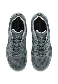 Scarpe atletiche grigie con tomaia in rete, sovrapposizioni testurizzate e accenti riflettenti. Presentano lacci e un colletto imbottito per il comfort.