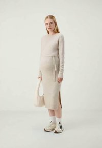 Pleteni dolgo-sleeve obleka v svetlo bež barvi, ima pas z obročkom, stranske razpoke, mehak material in jo kombiniramo z belimi supergami ter torbico.