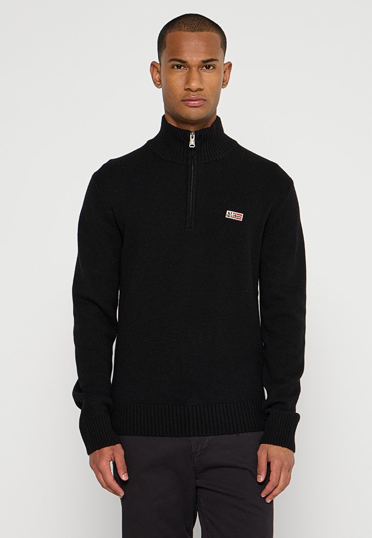 Schwarzer Strickpullover mit hohem, geripptem Kragen und halbem Reißverschluss. Verfügt über ein kleines rot-weißes Logo-Patch auf der oberen linken Seite.