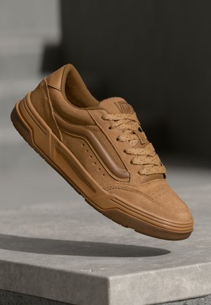 Barna, textúrázott felületű, kerek fűzővel ellátott, perforált lyukakkal a oldalán rendelkező, puha bőr sneaker. Vastag gumitalp.