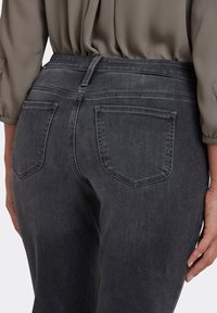 Mörkgrå jeans med klassisk femficksdesign, synliga sömmar och en slät denimtextur. Midjebandet sitter i naturlig midjehöjd.