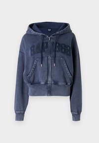 Skraćeni tamnoplavi hoodie s patentnim zatvaračem sprijeda, kapuljačom s šnuricom i uzdignutim natpisom "GAP 1969". Ima dva prednja džepa i rebraste manžete.
