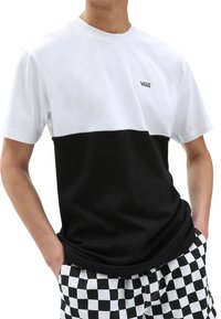 Camiseta de manga corta en blanco y negro con un diseño de bloques de color. Presenta un logo de Vans en el pecho y una textura de algodón suave.
