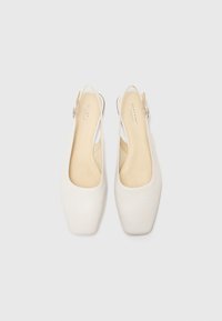 Pantofi slingback albi cu un design cu vârf pătrat. Material din piele netedă, brant bej deschis și detaliu cu cataramă argintie.