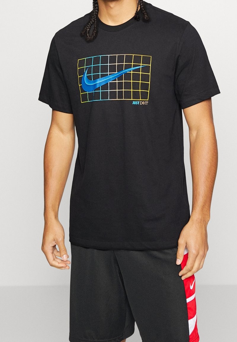 Camiseta de algodón negra con un logo azul de Nike Swoosh dentro de una rejilla, con acentos amarillos y azules y el texto "JUST DO IT" en la parte inferior.