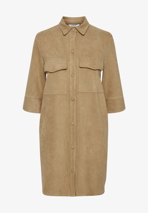 Vestido camisero de ante color arena con frente abotonado, cuello puntiagudo y dos bolsillos en el pecho; presenta un corte holgado y mangas de longitud media.