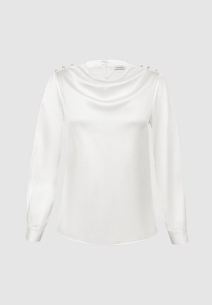 Λευκό σατέν πουκάμισο με μακριά μανίκια και λεπτομέρειες με πέρλες στα ώμο, καθώς και μικρό φερμουάρ στο πίσω μέρος, παρουσιασμένο σε απλό φόντο.