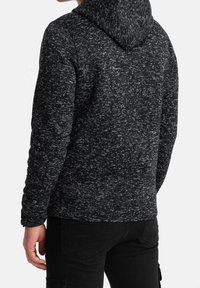Černá a šedě mramorovaná mikina s kapucí s texturovaným povrchem a stahovací šňůrkou na kapuci, s volným střihem a dlouhými rukávy.