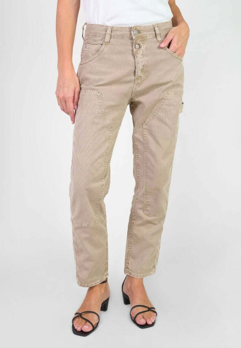 Beige cargobroek met meerdere zakken, textuurstof, rechte pijp pasvorm en een knoopsluiting. Gecombineerd met zwarte sandalen met bandjes.