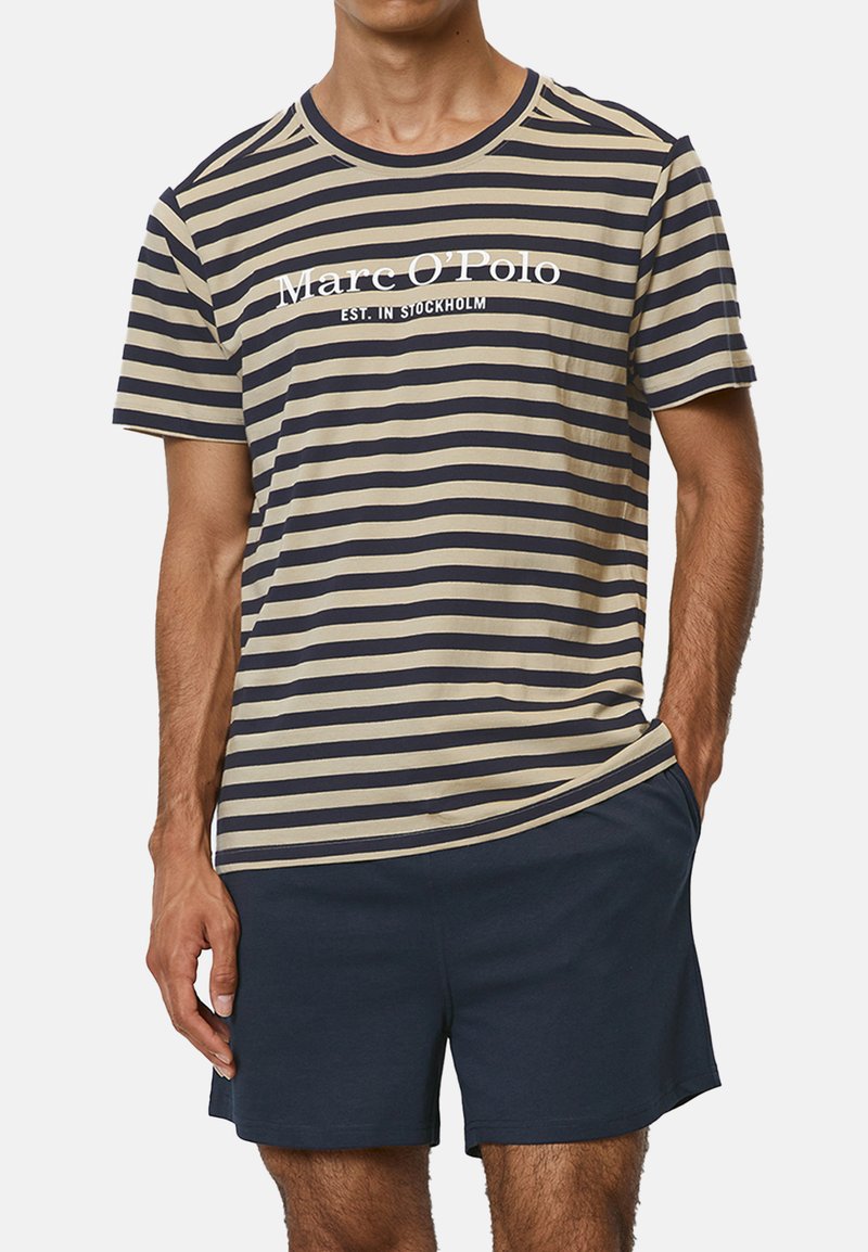 T-shirt à manches courtes rayé en beige et bleu marine, avec un col rond et un logo imprimé. Associé à un short bleu marine uni. Matière en coton doux.