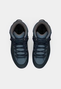 Středně vysoké tenisky v tmavě modré a šedé syntetické materiály. Mají texturované povrchy, kontrastní tkaničky s tečkovaným vzorem a polstrovaný límec.