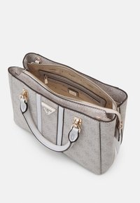 Sac à main de designer gris clair avec poignées blanches, accents dorés, fermeture éclair ouverte révélant un intérieur beige avec poche zippée et doublure portant le nom de la marque.