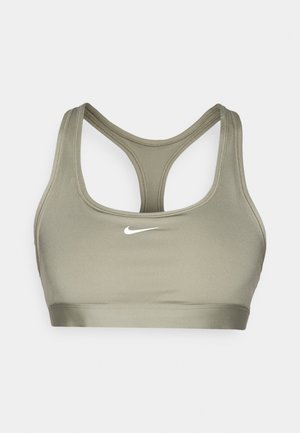 Sujetador deportivo en verde oliva, hecho de una tela suave. Presenta un diseño de espalda nadadora y un pequeño logo blanco de Nike en la parte frontal.