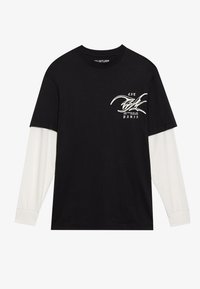 Sort t-shirt med lange hvide ærmer. Har et grafisk design i hvid med teksten "EST PARIS" på forsiden. Lavet af bomulds materiale.